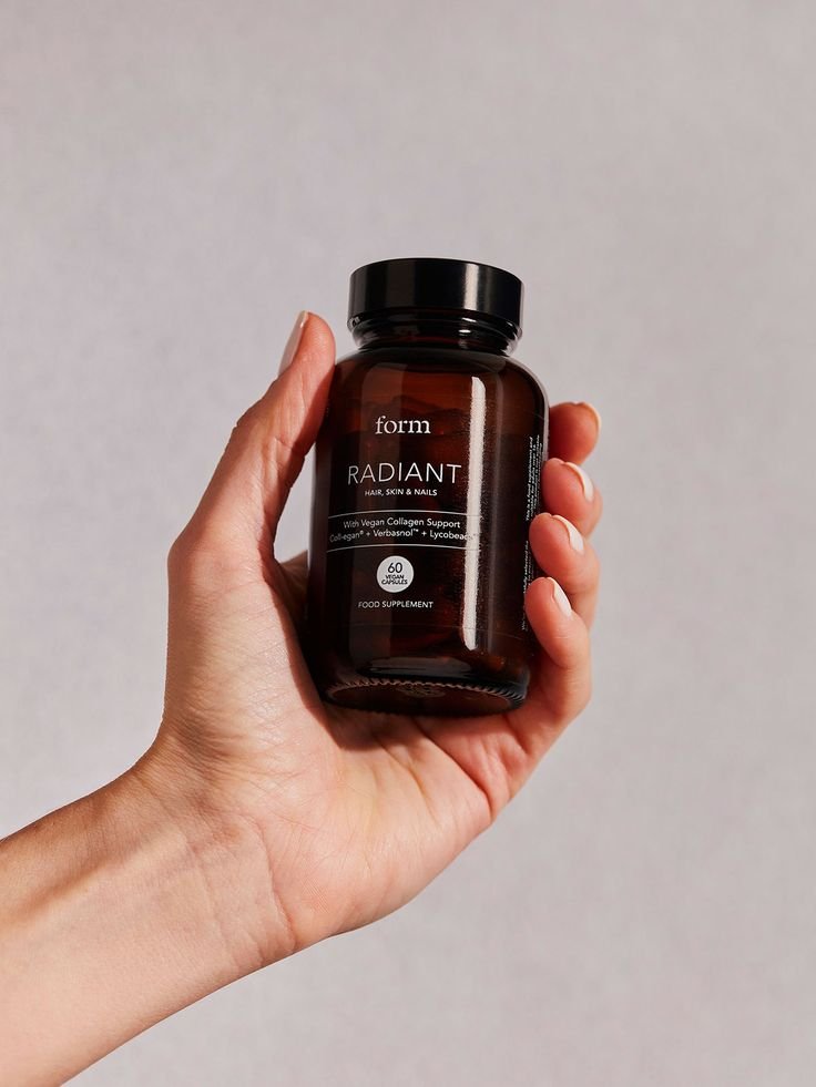 Hand holding a premium nutra supplement bottle for hair, skin and nails